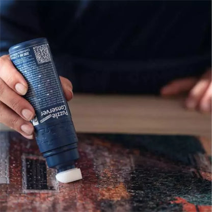 Person using a puzzle Glue bottle on a puzzle
